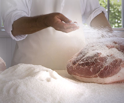 La salagione: la coscia fresca ricoperta di sale sul bancone